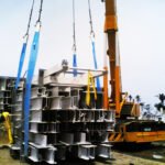 Crane lifting bundled fabricated steel components during a cargo handling operation