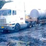Tractor head transporting cylindrical industrial project cargo on a low-bed trailer