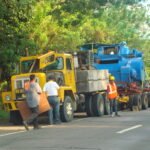 Heavy transport vehicle and crew stopped along a roadway during an equipment movement
