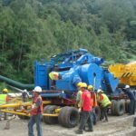 Crane and transport crew positioning heavy industrial equipment on a modular trailer