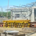Modular transport beams and support equipment staged at an industrial project site