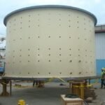 Large cylindrical mining equipment positioned at an industrial staging area
