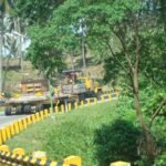 Heavy transport vehicle navigating a winding road through a rural area