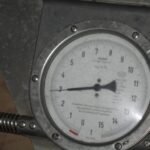 Close-up of a portable scale measuring the wheel load of a heavy transport trailer