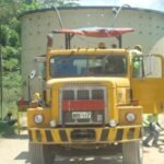 Front view of a tractor head transporting oversized cylindrical equipment