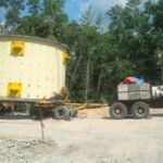 Oversized cylindrical equipment transported on a modular trailer at a project site